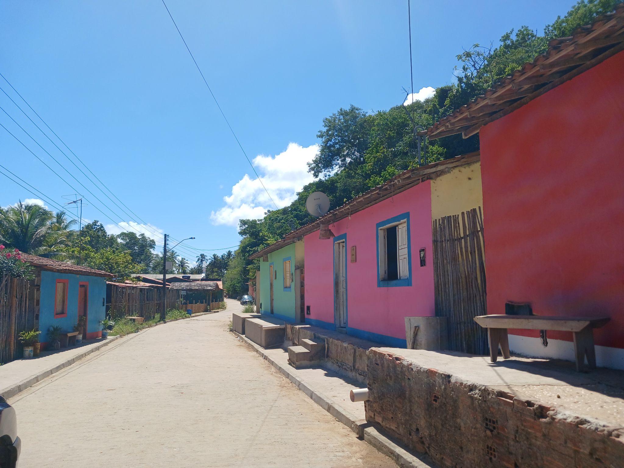 Povoado de Palateia na Lagoa do Roteiro — casas coloridas com placas das matriarcas, inspiração para os Saquis